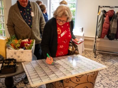 Joy Wilcox picking out her lucky or unlucky numbers on the raffle board